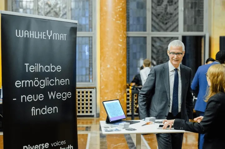 A guest at an exhibitor stand with a tablet demo