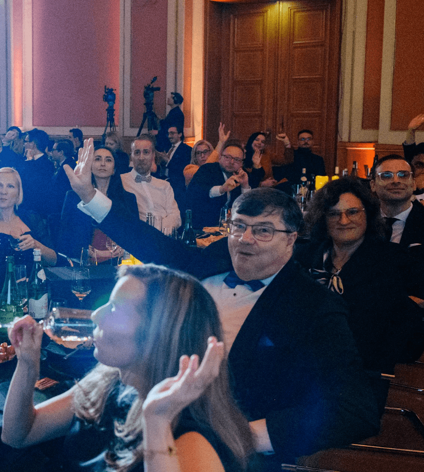 Guests gathered around a laptop demo at the Gala